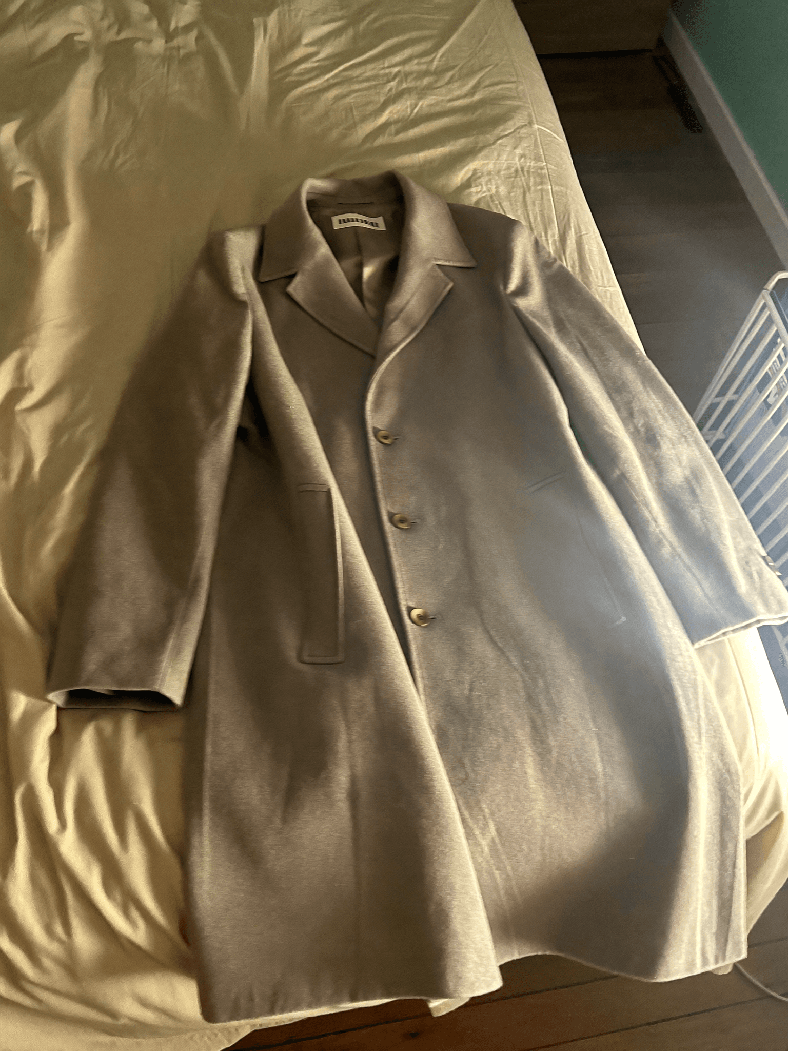 Casual smartphone photo of a beige wool coat
